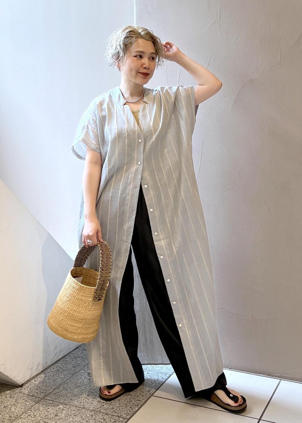 ブラック系のその他パンツ、イエロー系のタンクトップ、ブルー系のワンピースを着用したレディースの夏コーディネートの3枚目の写真