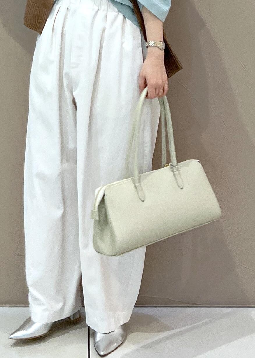 ホワイト系のボストンバッグ、イエロー系のカーディガン/ボレロ、ホワイト系のその他パンツを着用したレディースの春コーディネートの8枚目の写真