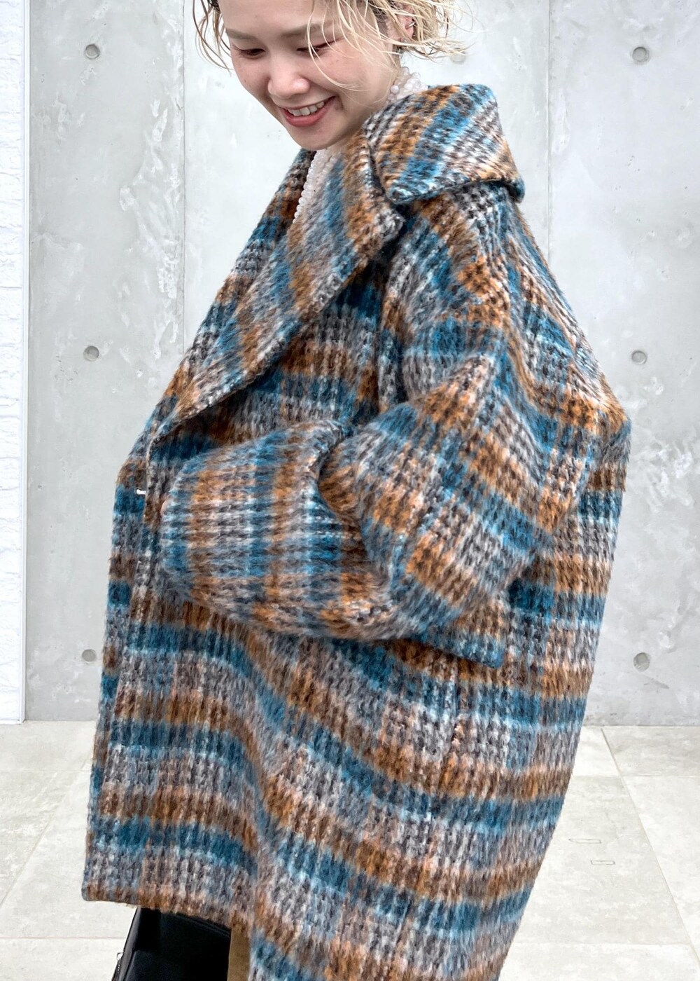 ブラック系のベスト、ブルー系のピーコート、ブラック系のボディバッグ/ウエストポーチを着用したレディースの秋コーディネートの6枚目の写真