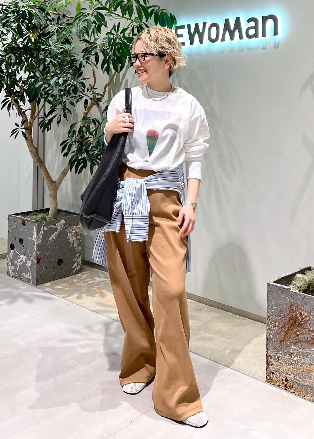 ブラック系のトートバッグ、ブルー系のシャツ/ブラウス、ホワイト系のTシャツ/カットソーを着用したレディースの冬コーディネートの2枚目の写真