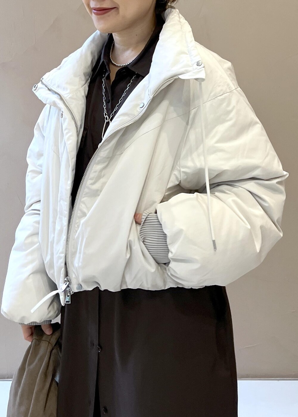 ホワイト系のダウンジャケット/コート、グレー系のハンドバッグ、グレー系のワンピースを着用したレディースの秋コーディネートの8枚目の写真