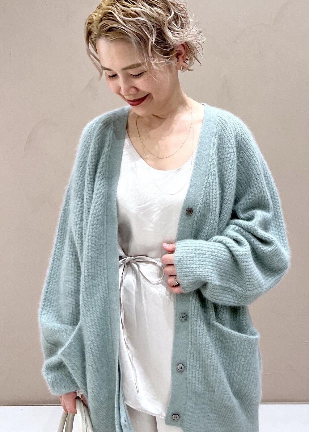 ホワイト系のTシャツ/カットソー、グリーン系のカーディガン/ボレロ、ホワイト系のカーゴパンツを着用したレディースの秋コーディネートの7枚目の写真