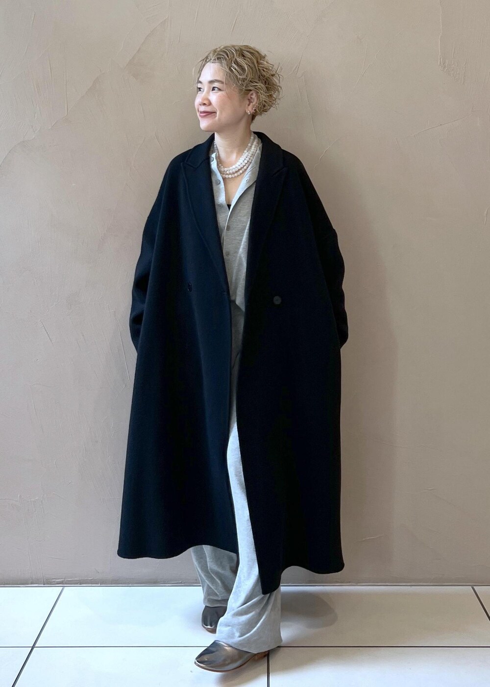 ブラック系のハンドバッグ、ブラック系のその他アウター、シルバー系のパンプスを着用したレディースの秋コーディネートの4枚目の写真