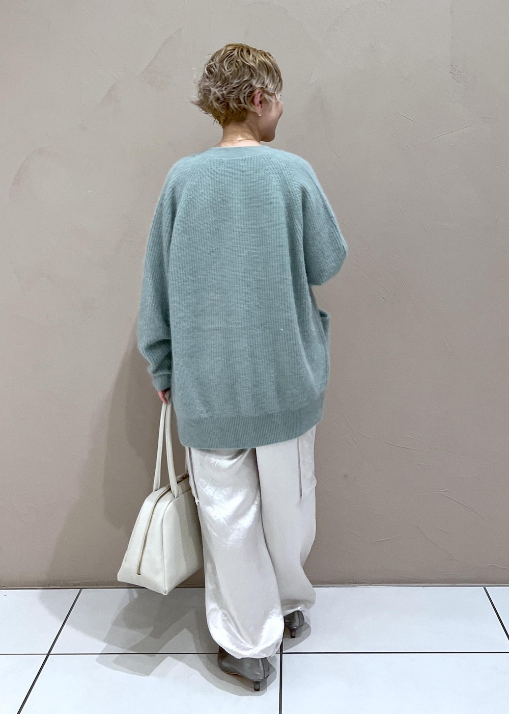 ホワイト系のTシャツ/カットソー、グリーン系のカーディガン/ボレロ、ホワイト系のカーゴパンツを着用したレディースの秋コーディネートの5枚目の写真