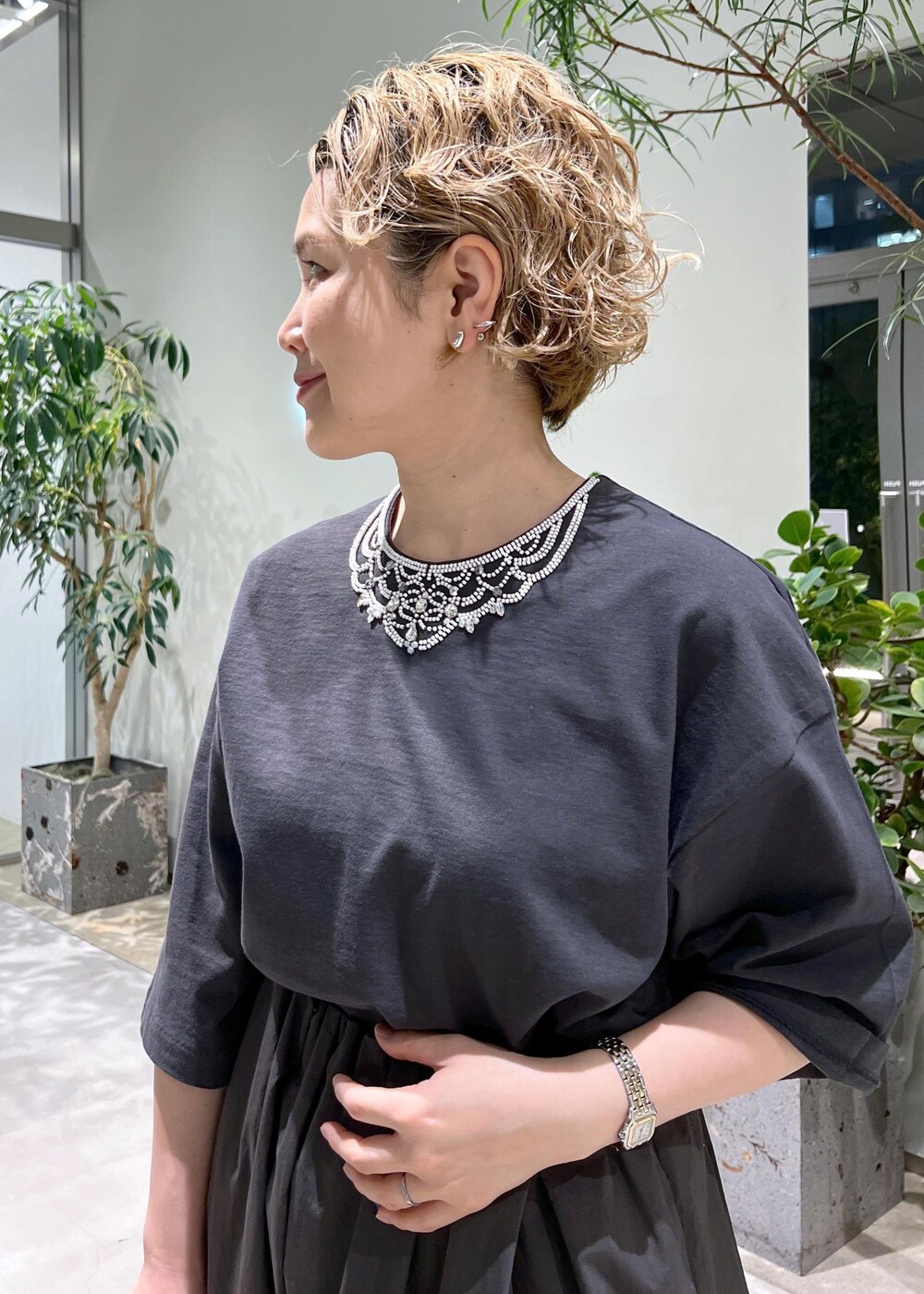 グレー系のスカート、グレー系のTシャツ/カットソー、ホワイト系のサンダルを着用したレディースの春コーディネートの7枚目の写真