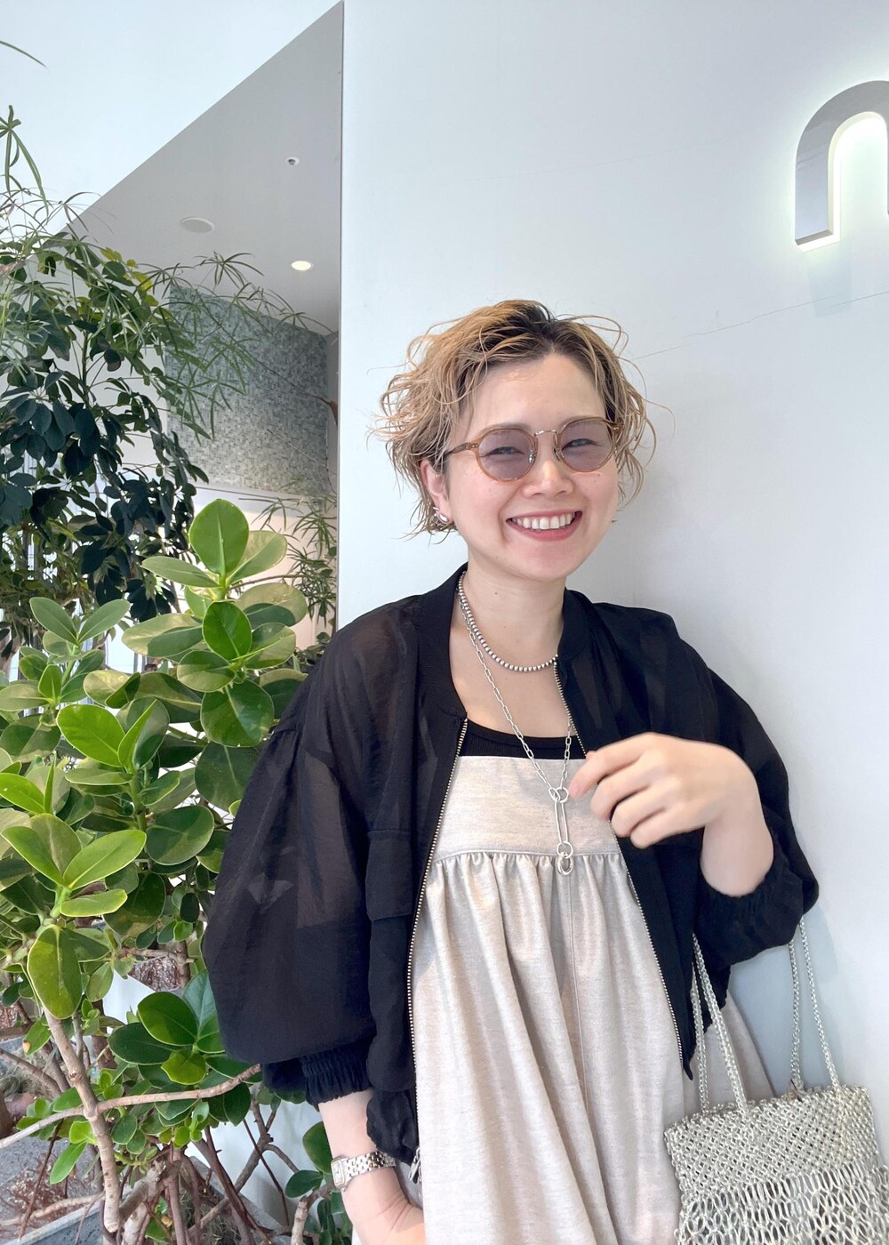 ブラック系のブルゾン、ブラック系のタンクトップ、シルバー系のトートバッグを着用したレディースの春コーディネートの7枚目の写真