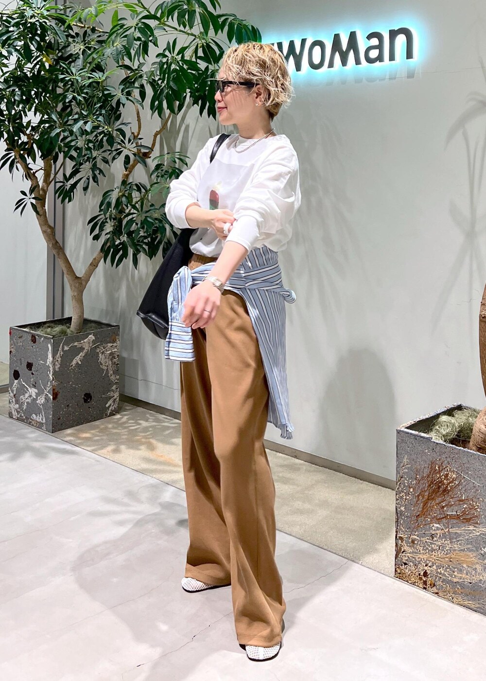 ブラック系のトートバッグ、ブルー系のシャツ/ブラウス、ホワイト系のTシャツ/カットソーを着用したレディースの冬コーディネートの4枚目の写真