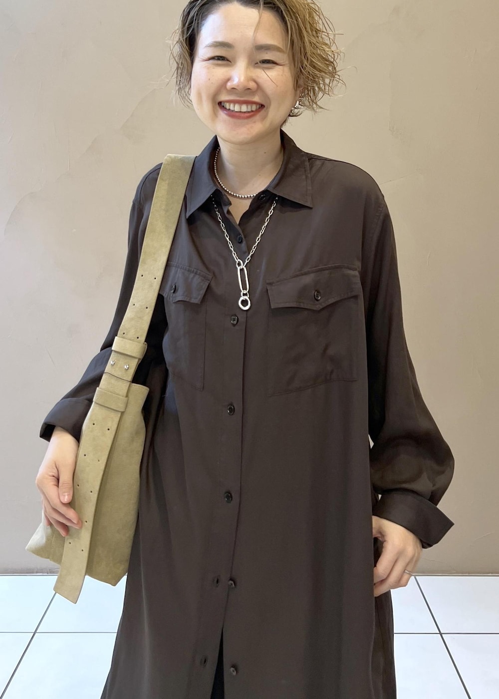 ベージュ系のショルダーバッグ、グレー系のワンピース、ブラック系のブーツを着用したレディースの秋コーディネートの8枚目の写真