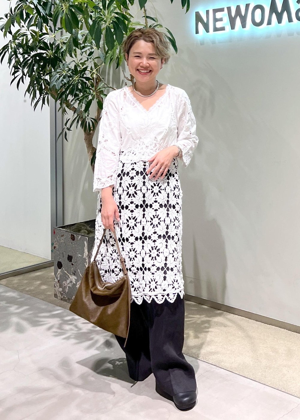 ブラック系のスラックス、ブルー系のシャツ/ブラウス、ブラウン系のショルダーバッグを着用したレディースの夏コーディネートの3枚目の写真