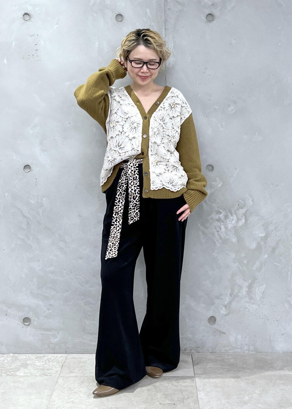 イエロー系のカーディガン/ボレロ、シルバー系のショルダーバッグ、ブラック系のその他パンツを着用したレディースの冬コーディネートの4枚目の写真