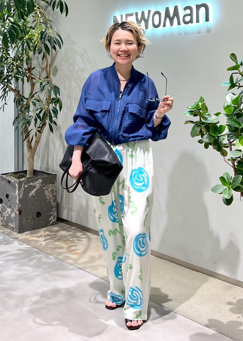 ブラック系のサンダル、ブルー系のブルゾン、ブラック系のサングラスを着用したレディースの春コーディネートの3枚目の写真