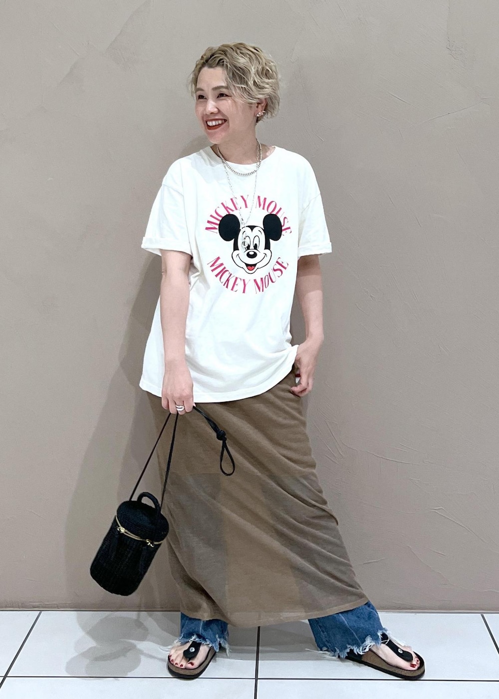 ブラック系のショルダーバッグ、ホワイト系のTシャツ/カットソー、ブルー系のデニムパンツを着用したレディースの夏コーディネートの3枚目の写真