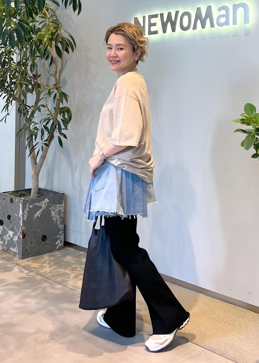 ブラック系のその他パンツ、ベージュ系のTシャツ/カットソー、ベージュ系のスニーカーを着用したレディースの春コーディネートの4枚目の写真