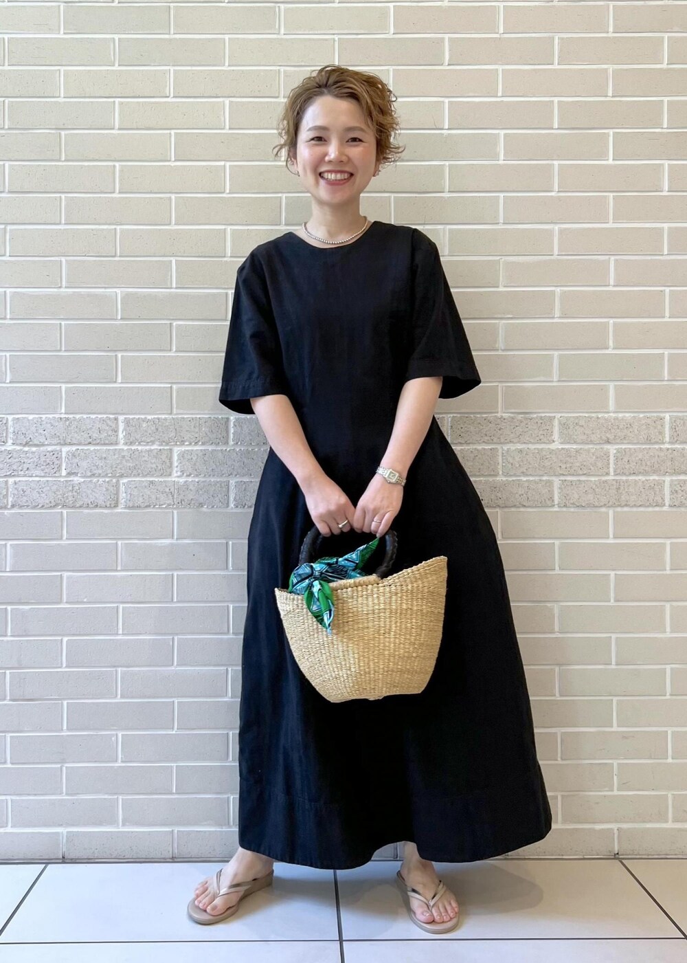 ベージュ系のサンダル、ベージュ系のカーディガン/ボレロ、ブラック系のワンピースを着用したレディースの夏コーディネートの4枚目の写真
