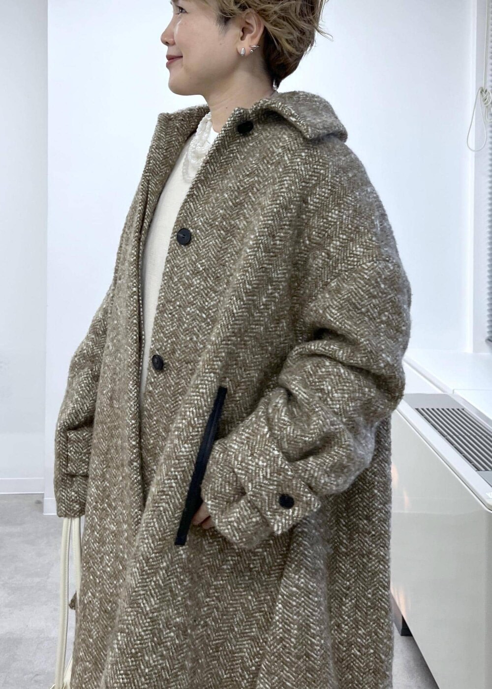 ホワイト系のスウェット、ベージュ系のステンカラーコート、ブラウン系のその他パンツを着用したレディースの秋コーディネートの6枚目の写真