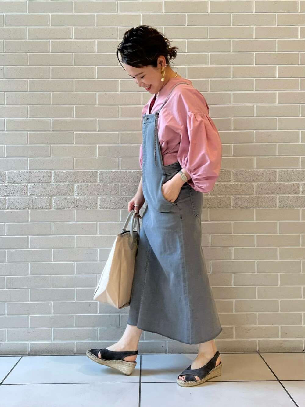 ピンク系のシャツ/ブラウス、グレー系のワンピース、ベージュ系のトートバッグを着用したレディースの春コーディネートの3枚目の写真