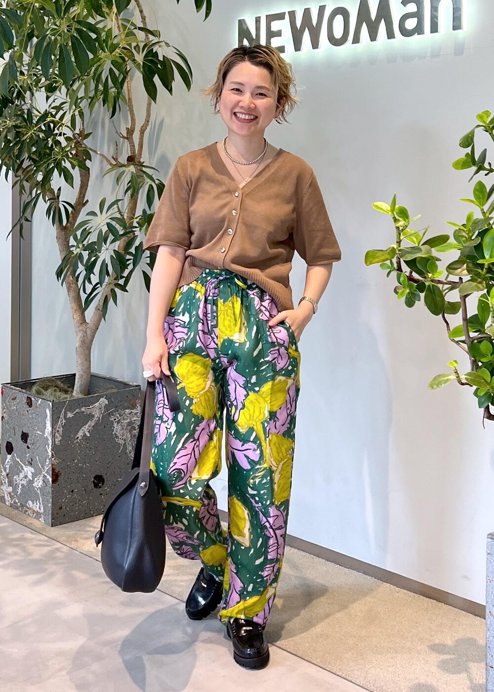 ブラック系のローファー、イエロー系のカーディガン/ボレロ、グリーン系のその他パンツを着用したレディースの夏コーディネートの3枚目の写真