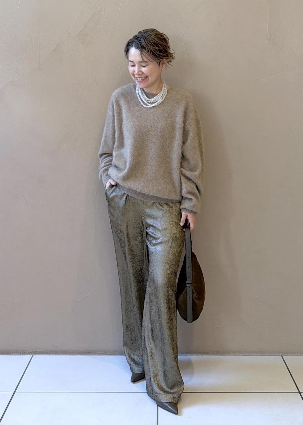 ゴールド系のその他パンツ、ベージュ系のニット/セーター、グリーン系のパンプスを着用したレディースの冬コーディネートの2枚目の写真