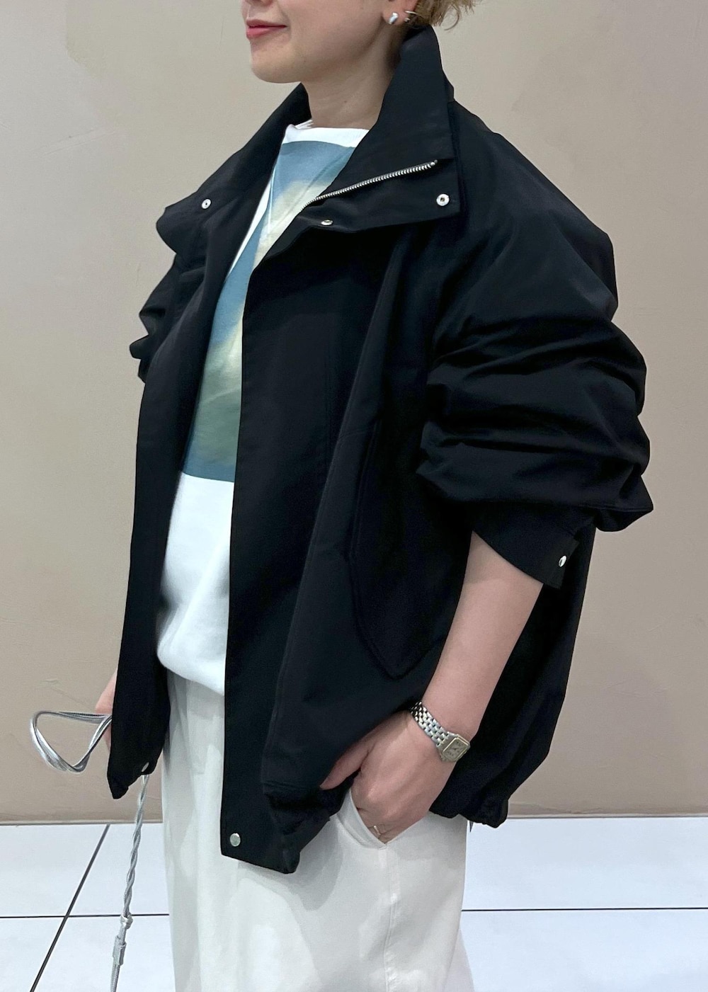 ブラック系のブルゾン、ホワイト系のその他パンツ、シルバー系のショルダーバッグを着用したレディースの春コーディネートの4枚目の写真