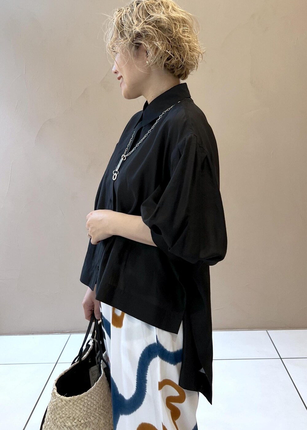 ブラック系のサンダル、ホワイト系のかごバッグ、ブラック系のシャツ/ブラウスを着用したレディースの春コーディネートの7枚目の写真