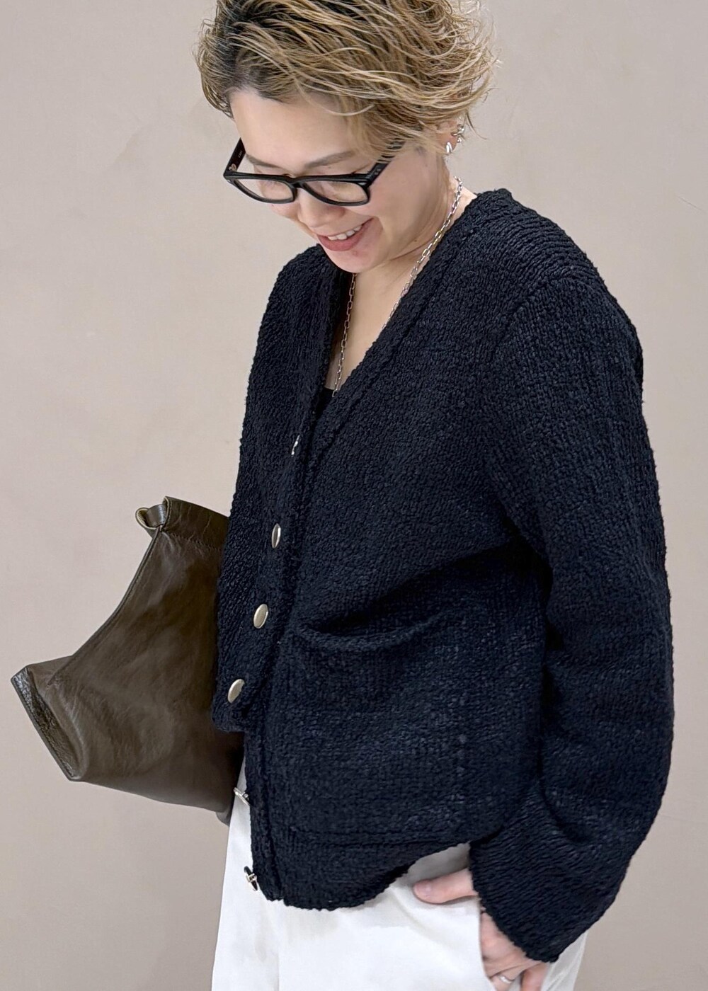 ブラック系のカーディガン/ボレロ、ホワイト系のサロペット/オーバーオール、ブラック系のローファーを着用したレディースの冬コーディネートの5枚目の写真