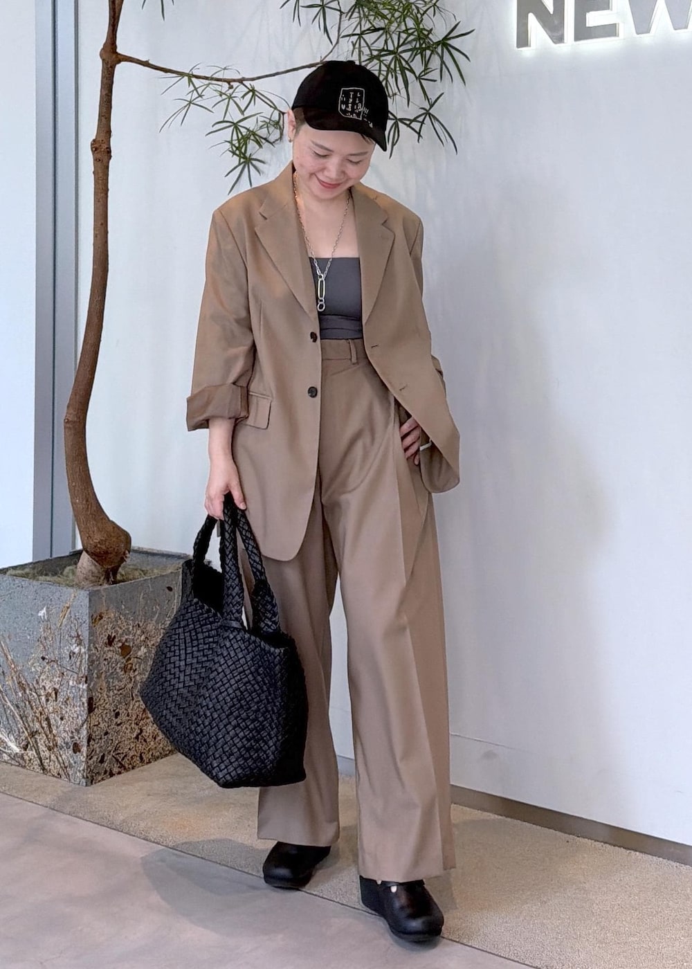 ベージュ系のその他パンツ、ベージュ系のテーラードジャケット、ブラック系のトートバッグを着用したレディースの秋コーディネートの2枚目の写真