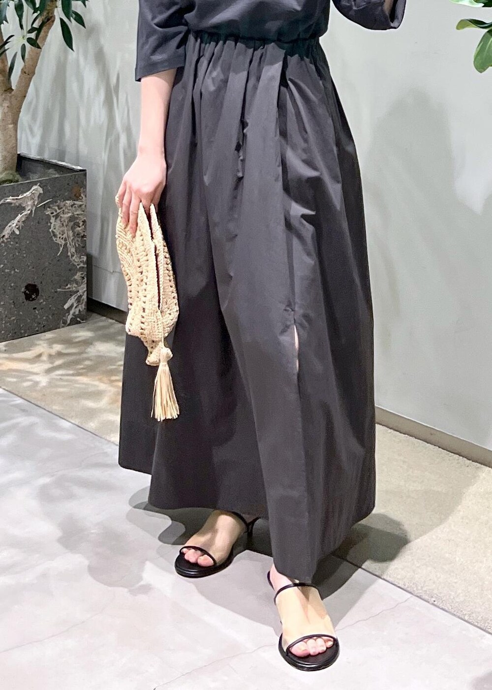 グレー系のスカート、グレー系のTシャツ/カットソー、ホワイト系のサンダルを着用したレディースの春コーディネートの9枚目の写真