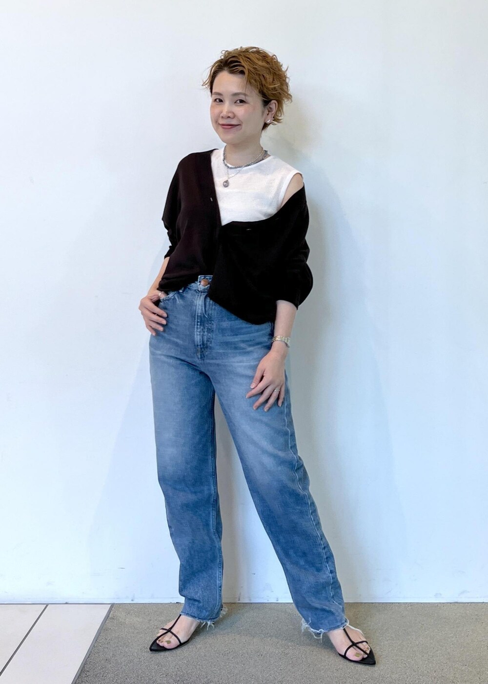 ブラック系のサンダル、ブラウン系のカーディガン/ボレロ、ブルー系のデニムパンツを着用したレディースの夏コーディネートの2枚目の写真