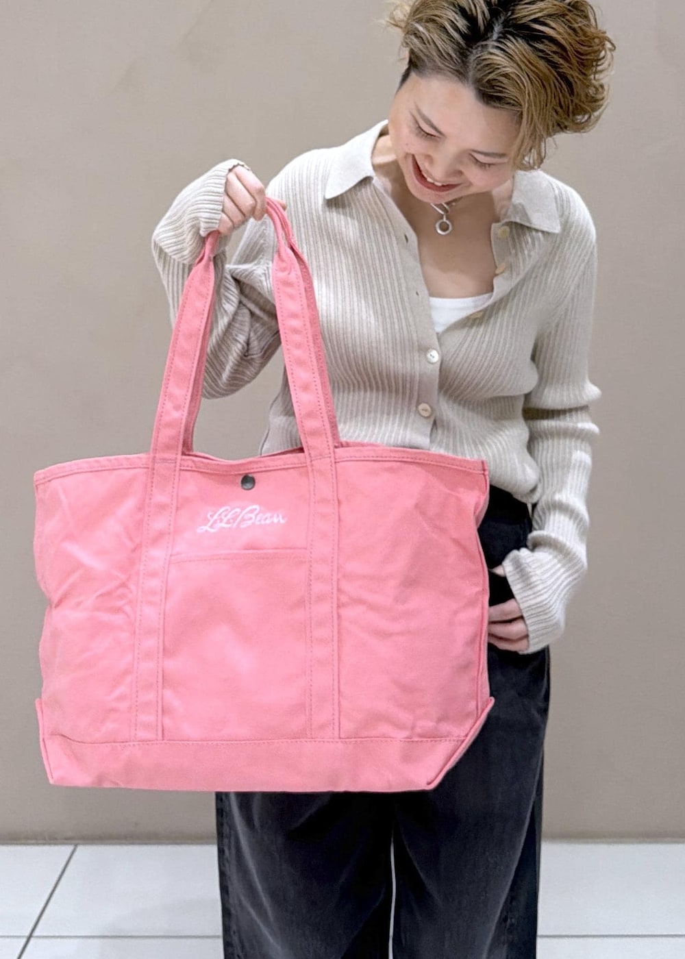 ベージュ系のカーディガン/ボレロ、ピンク系のトートバッグ、ブラック系のデニムパンツを着用したレディースの冬コーディネートの10枚目の写真