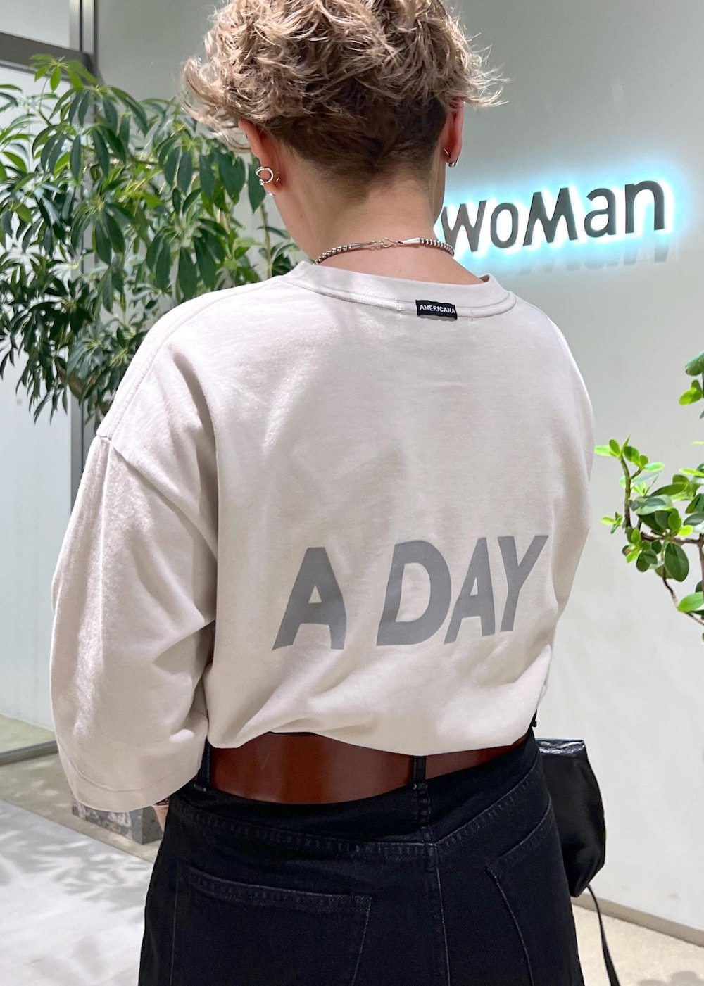 グレー系のデニムパンツ、ブラック系のショルダーバッグ、ホワイト系のTシャツ/カットソーを着用したレディースの夏コーディネートの7枚目の写真