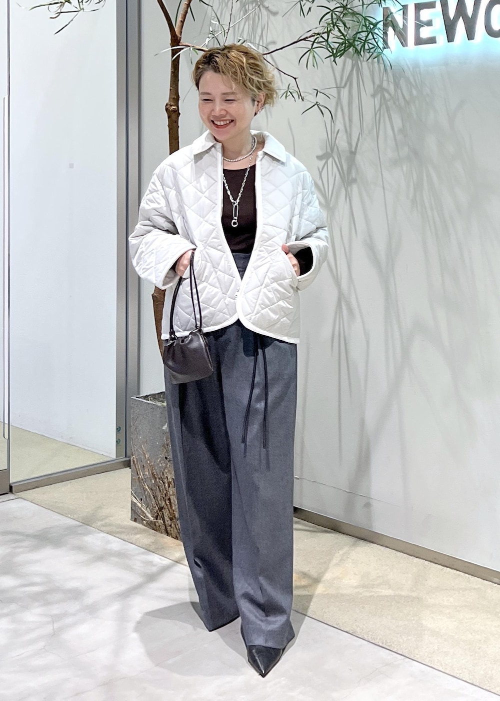 ピンク系のブルゾン、ブラウン系のハンドバッグ、ブラック系のパンプスを着用したレディースの秋コーディネートの3枚目の写真