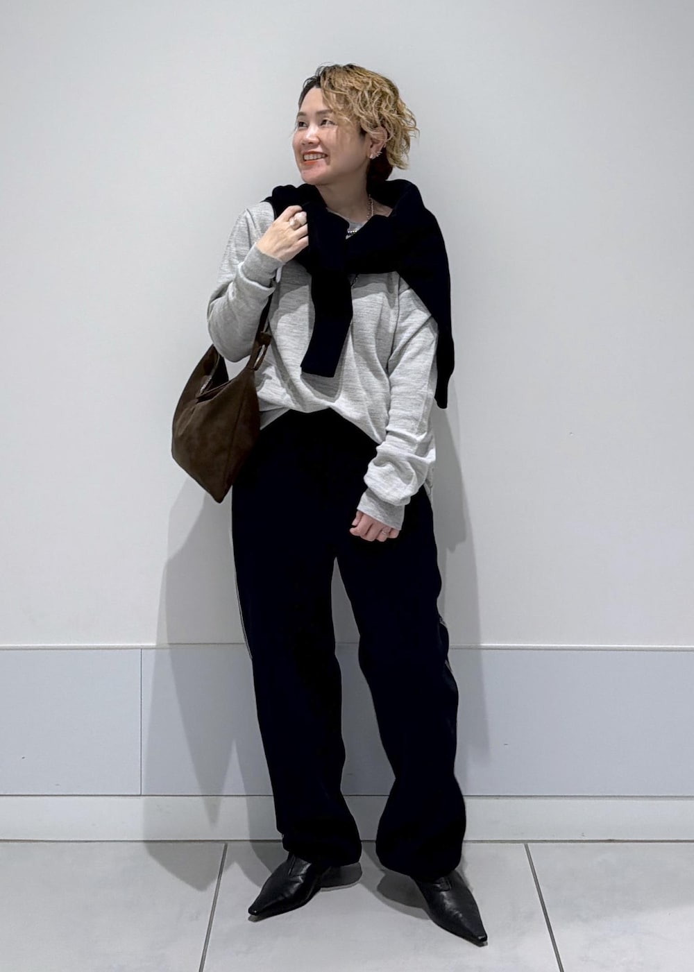 ブラック系のその他パンツ、ブラック系のスウェット、ブラウン系のショルダーバッグを着用したレディースの秋コーディネートの4枚目の写真