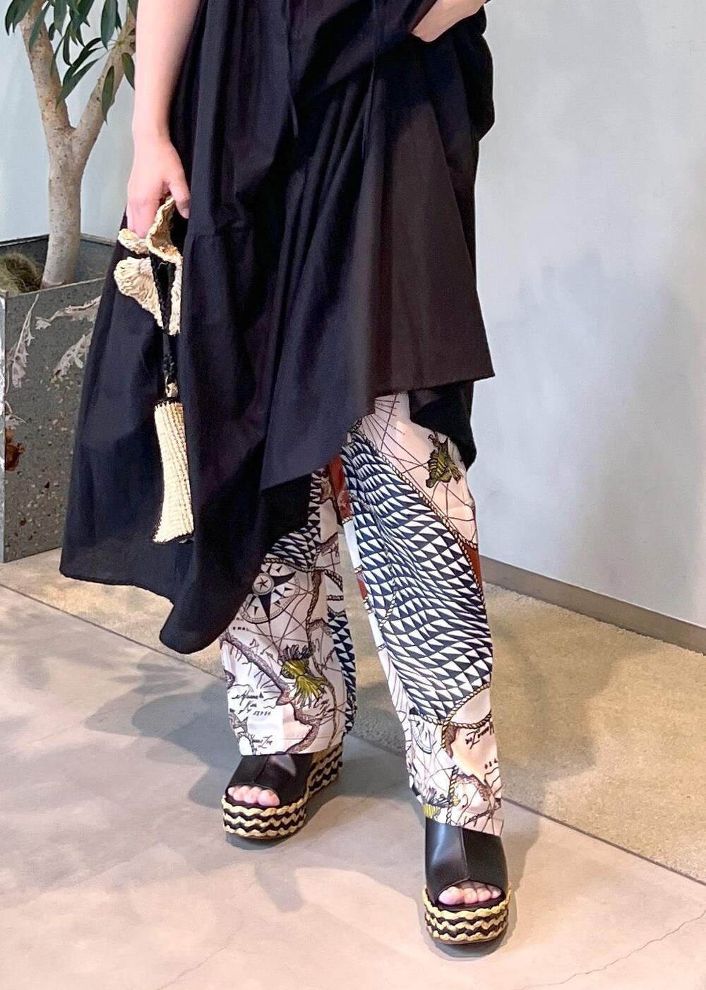 ブラック系のワンピース、ホワイト系のハンドバッグ、ブラック系のサンダルを着用したレディースの夏コーディネートの8枚目の写真