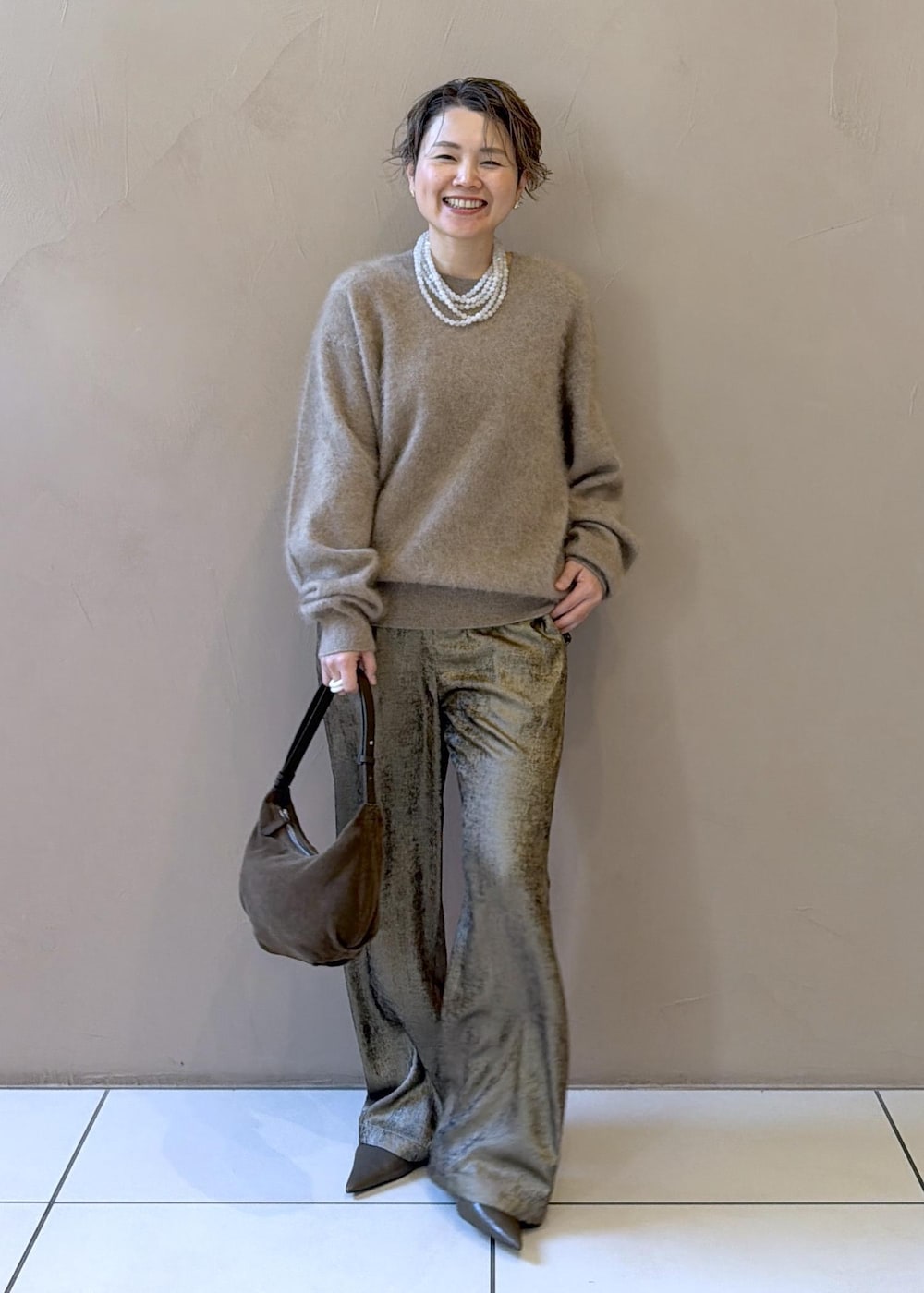 ゴールド系のその他パンツ、ベージュ系のニット/セーター、グリーン系のパンプスを着用したレディースの冬コーディネートの4枚目の写真