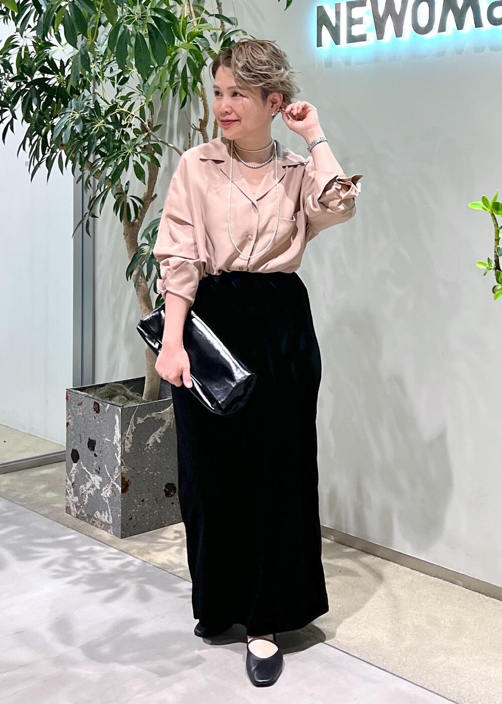 ブラック系のスカート、ピンク系のシャツ/ブラウス、ブラック系のショルダーバッグを着用したレディースの夏コーディネートの3枚目の写真
