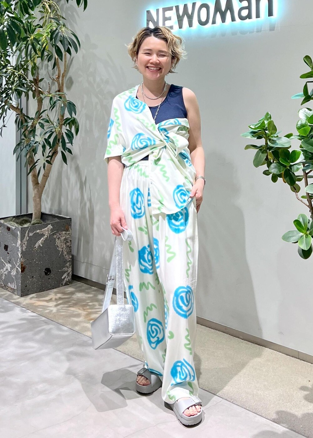 ブルー系のタンクトップ、シルバー系のショルダーバッグ、グレー系のサンダルを着用したレディースの春コーディネートの6枚目の写真