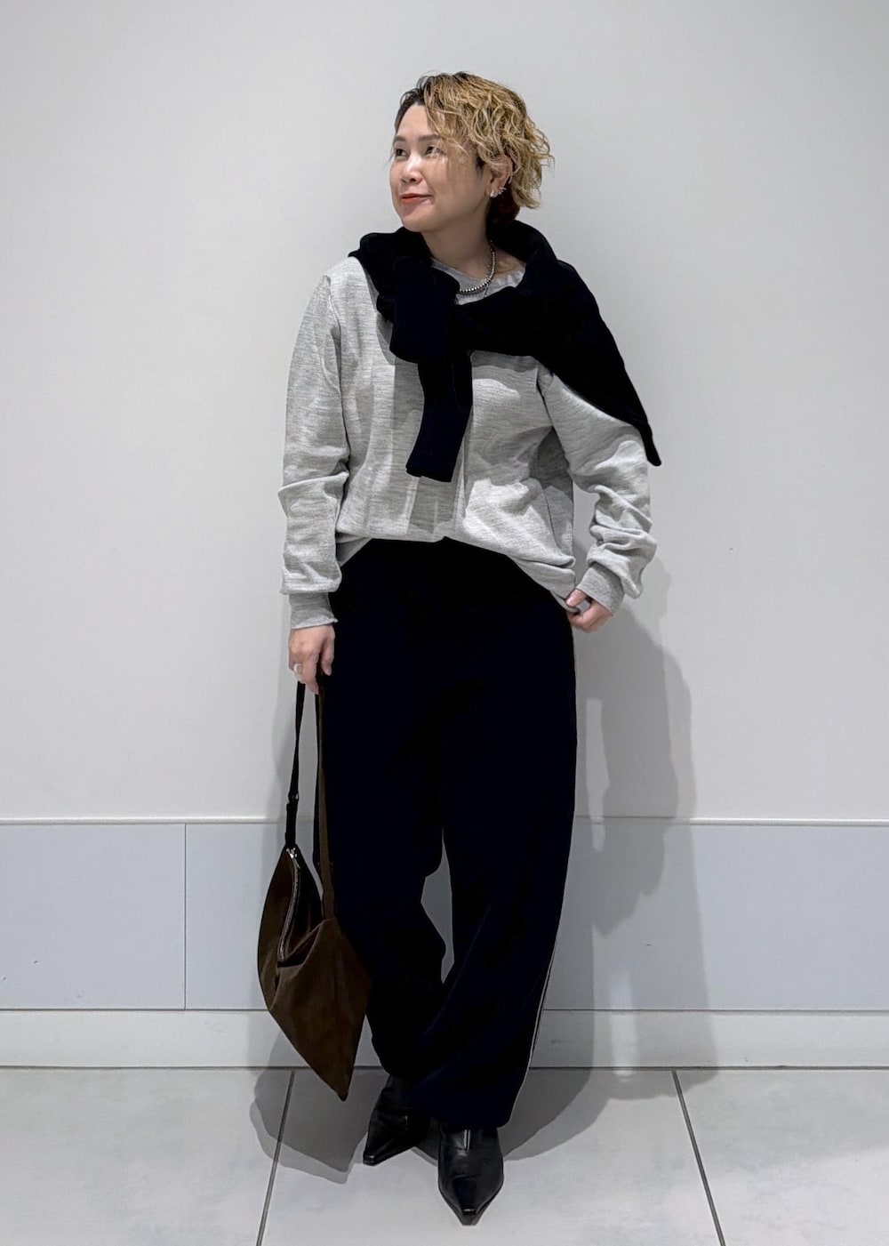 ブラック系のその他パンツ、ブラック系のスウェット、ブラウン系のショルダーバッグを着用したレディースの秋コーディネートの2枚目の写真