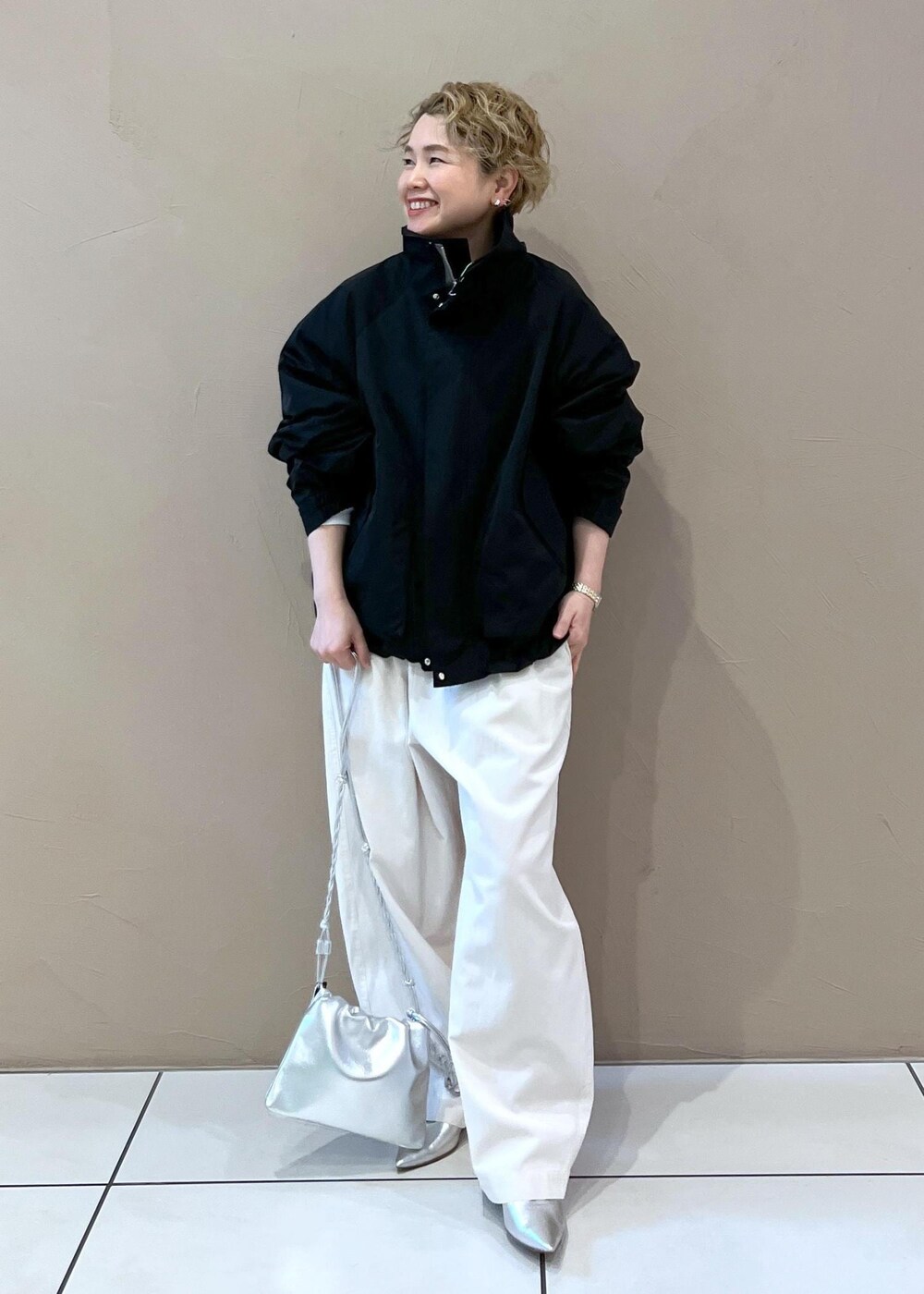 ブラック系のブルゾン、ホワイト系のその他パンツ、シルバー系のショルダーバッグを着用したレディースの春コーディネートの5枚目の写真