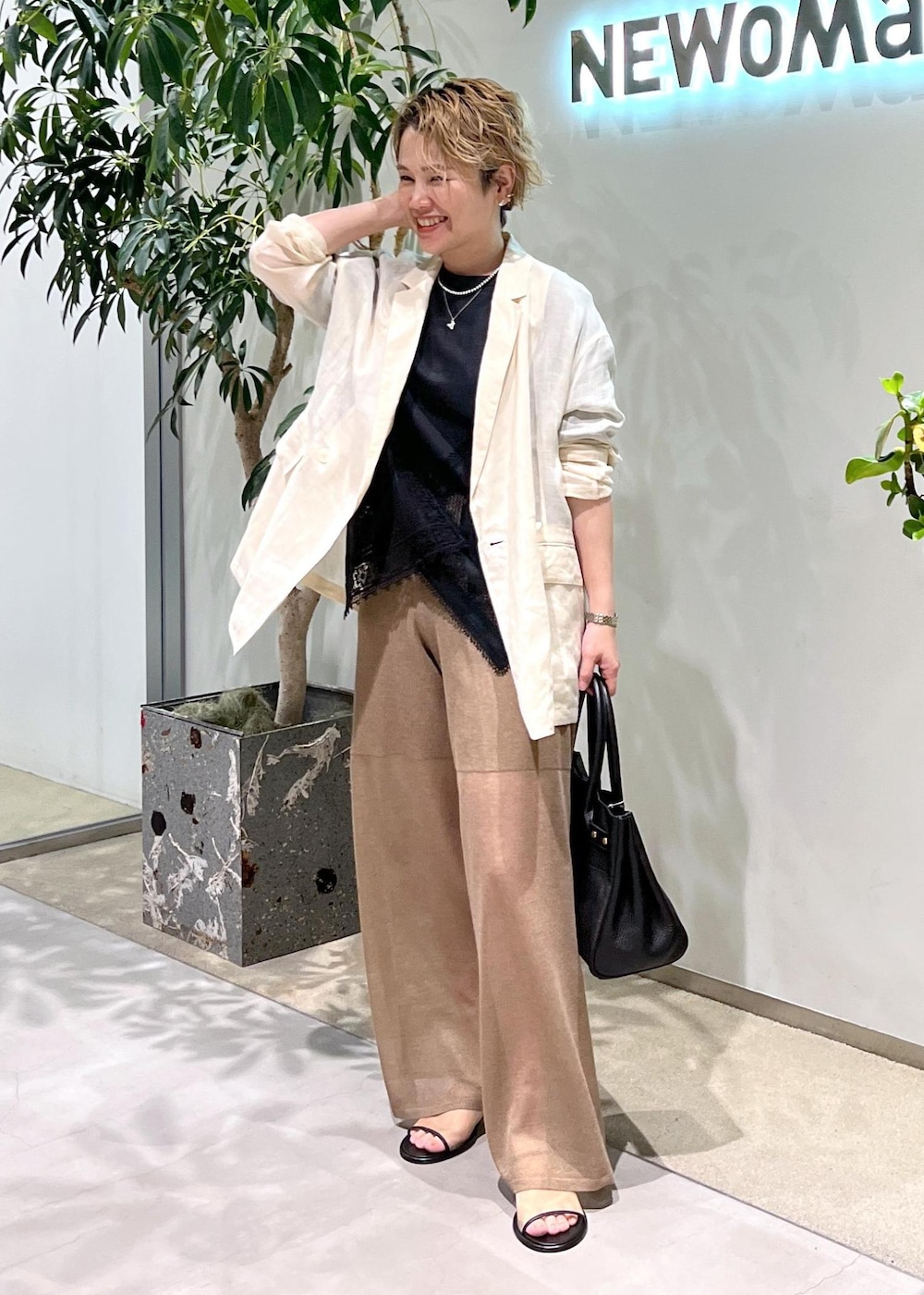 ブラック系のショルダーバッグ、ブラック系のTシャツ/カットソー、ホワイト系のテーラードジャケットを着用したレディースの夏コーディネートの3枚目の写真