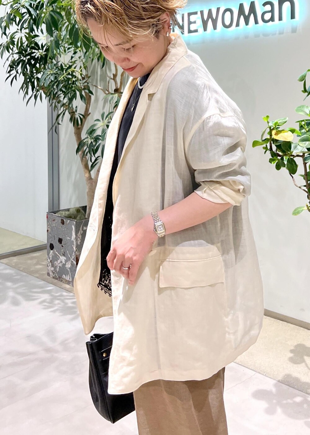 ブラック系のショルダーバッグ、ブラック系のTシャツ/カットソー、ホワイト系のテーラードジャケットを着用したレディースの夏コーディネートの7枚目の写真