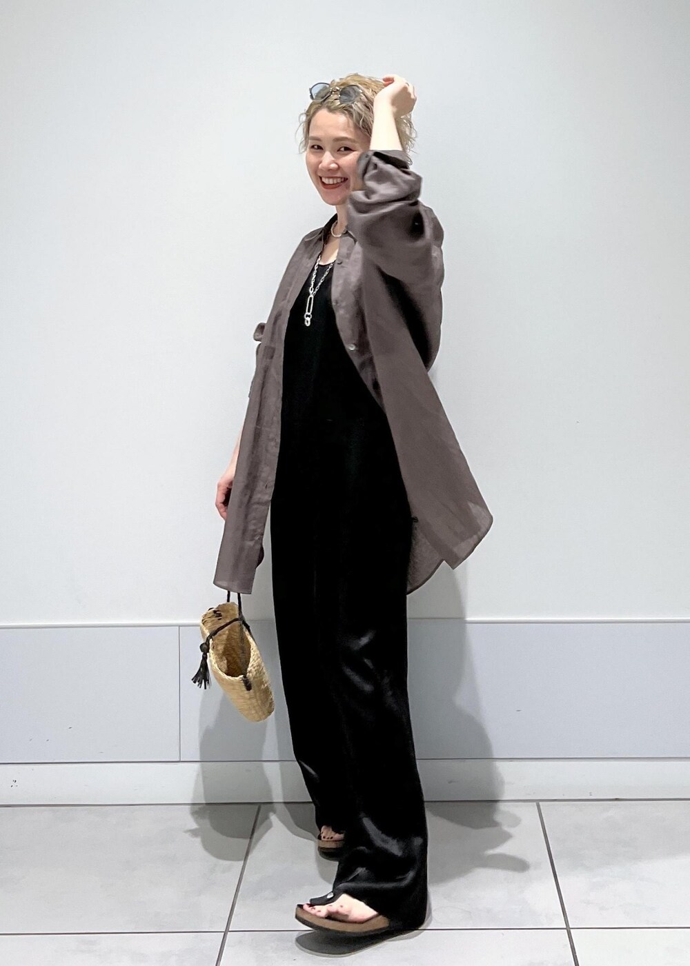 ベージュ系のかごバッグ、グレー系のシャツ/ブラウス、ブラック系のつなぎ/オールインワンを着用したレディースの夏コーディネートの4枚目の写真