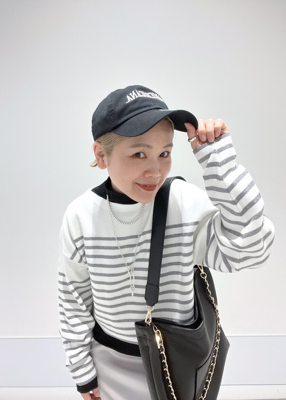 ブラック系のブーツ、ブラック系のTシャツ/カットソー、シルバー系のスカートを着用したレディースの冬コーディネートの10枚目の写真