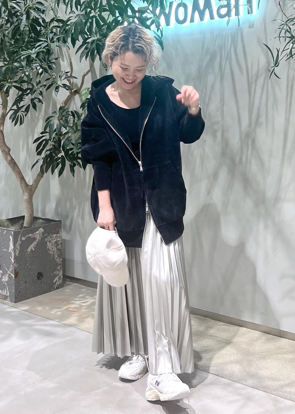 ベージュ系のスカート、ブラック系のタンクトップ、ブラック系のパーカーを着用したレディースの秋コーディネートの2枚目の写真