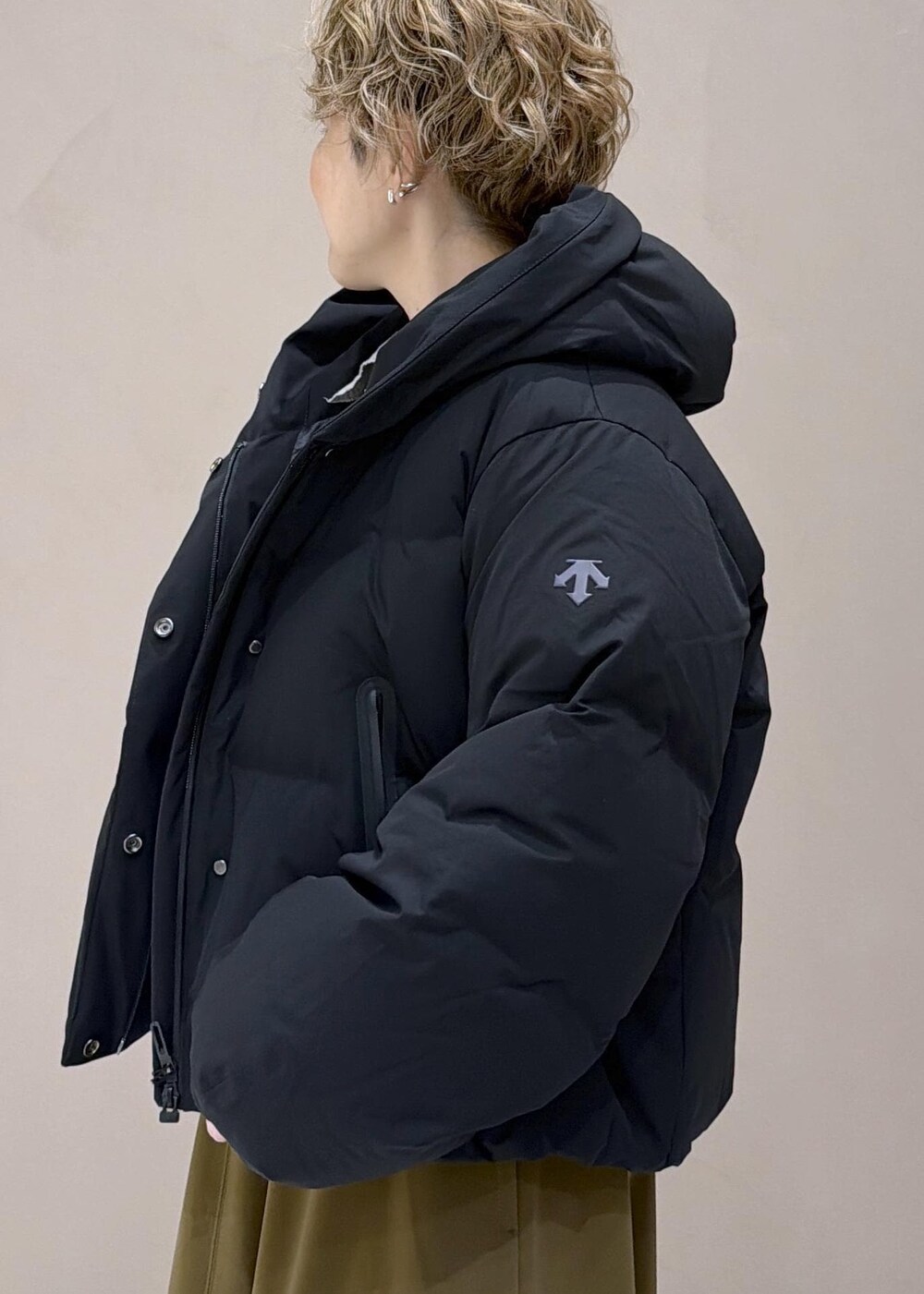 ブラウン系のスカート、ブラック系のダウンジャケット/コート、グレー系のニット/セーターを着用したレディースの冬コーディネートの8枚目の写真