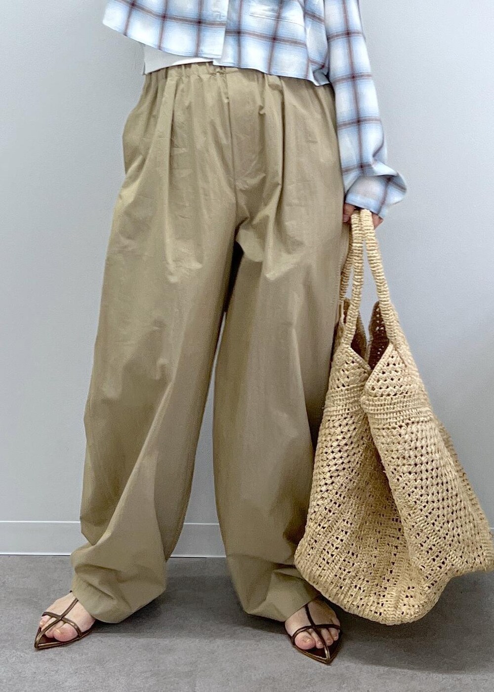 ホワイト系のかごバッグ、その他のサンダル、ベージュ系のその他パンツを着用したレディースの春コーディネートの7枚目の写真