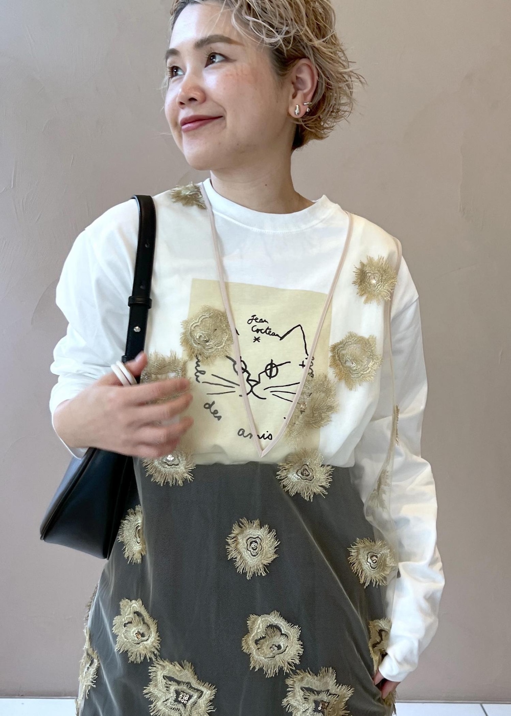 ブラック系のその他パンツ、ゴールド系のワンピース、ホワイト系のTシャツ/カットソーを着用したレディースの秋コーディネートの5枚目の写真