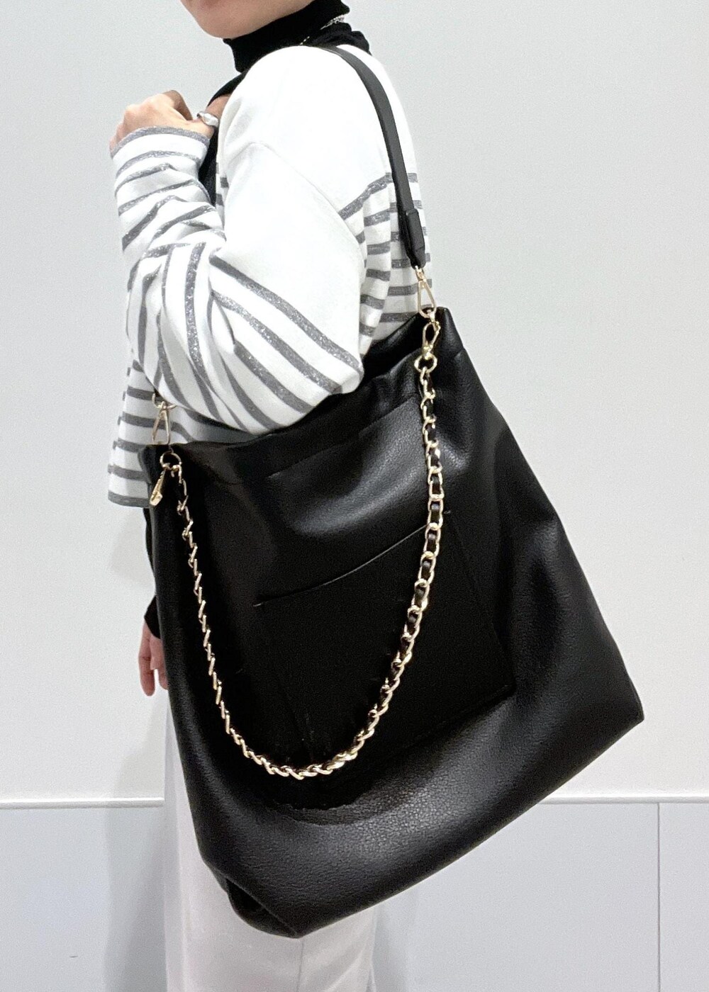 ブラック系のブーツ、ブラック系のTシャツ/カットソー、ブラック系のトートバッグを着用したレディースの冬コーディネートの10枚目の写真