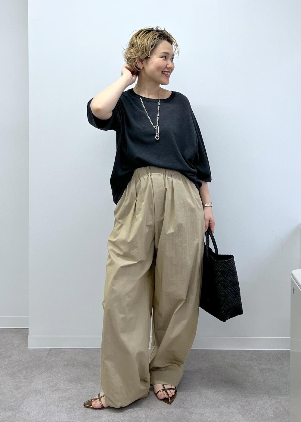 ブラック系のトートバッグ、グレー系のTシャツ/カットソー、その他のサンダルを着用したレディースの春コーディネートの4枚目の写真