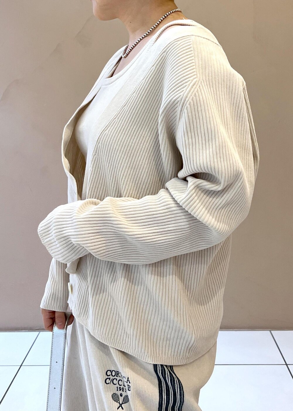 シルバー系のショルダーバッグ、ホワイト系のカーディガン/ボレロ、ホワイト系のその他パンツを着用したレディースの冬コーディネートの5枚目の写真