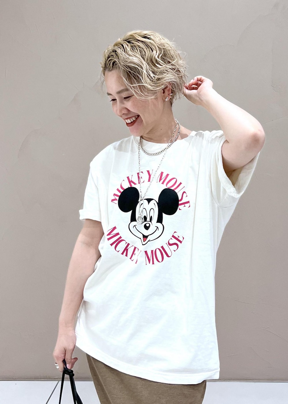 ブラック系のショルダーバッグ、ホワイト系のTシャツ/カットソー、ブルー系のデニムパンツを着用したレディースの夏コーディネートの7枚目の写真